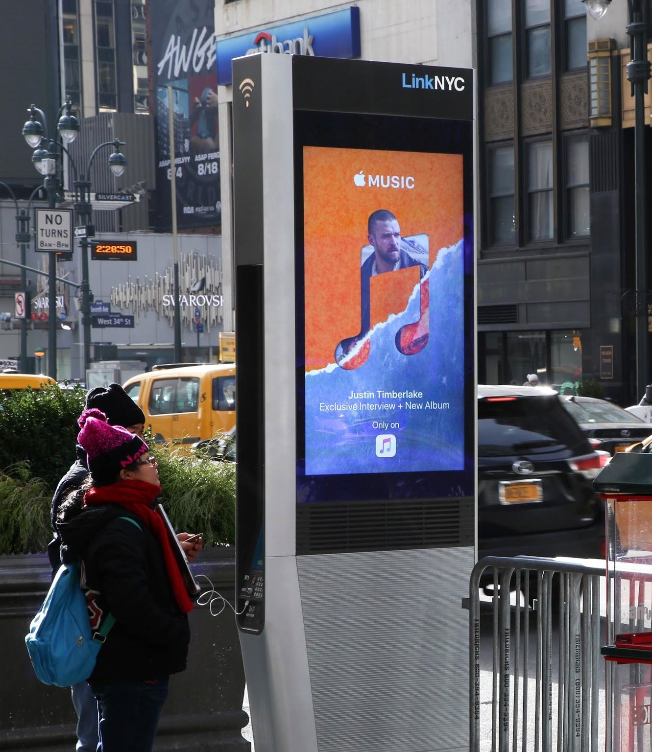 A LinkNYC kiosk near Times Square displaying an Apple Music advertisement for Justin Timberlake.